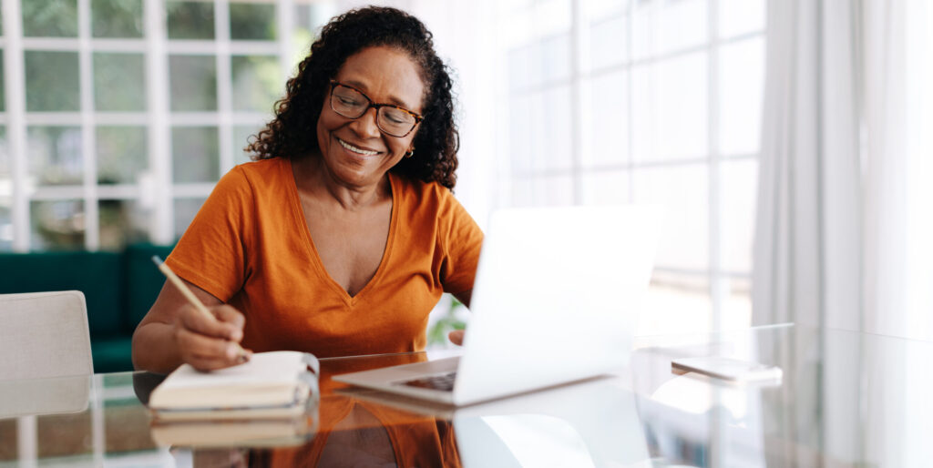 happy senior woman drafting her last will and testament in her journal