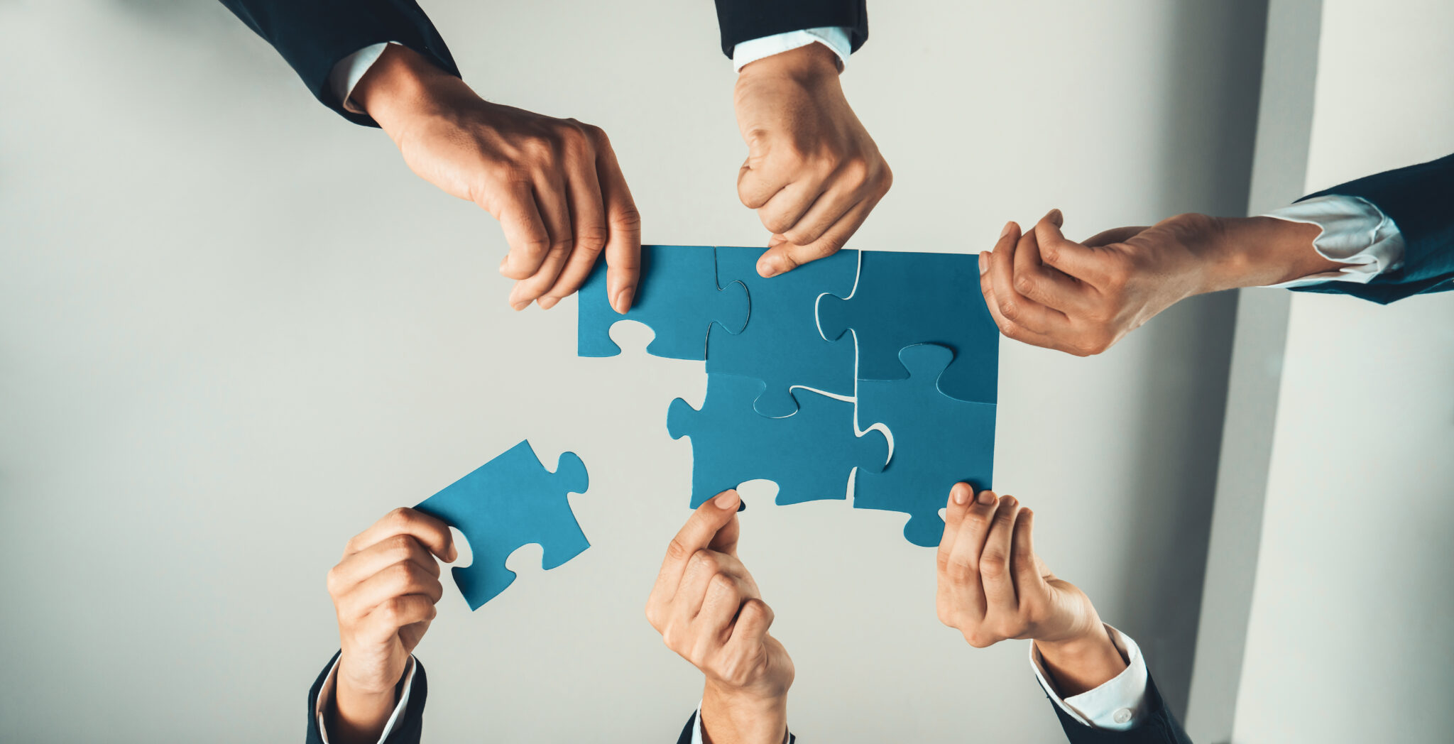 top view panorama banner of business team assembling jigsaw puzzle. shrewd