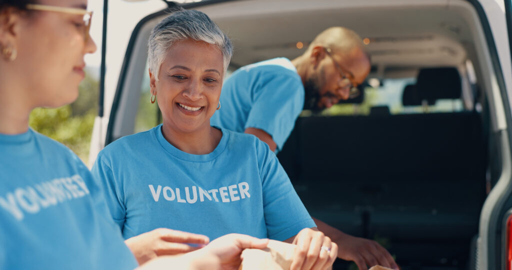 volunteer, donation and people with food package for charity event, teamwork and community programme. collaboration, volunteering and men and women with van for parcel, bags and grocery distribution