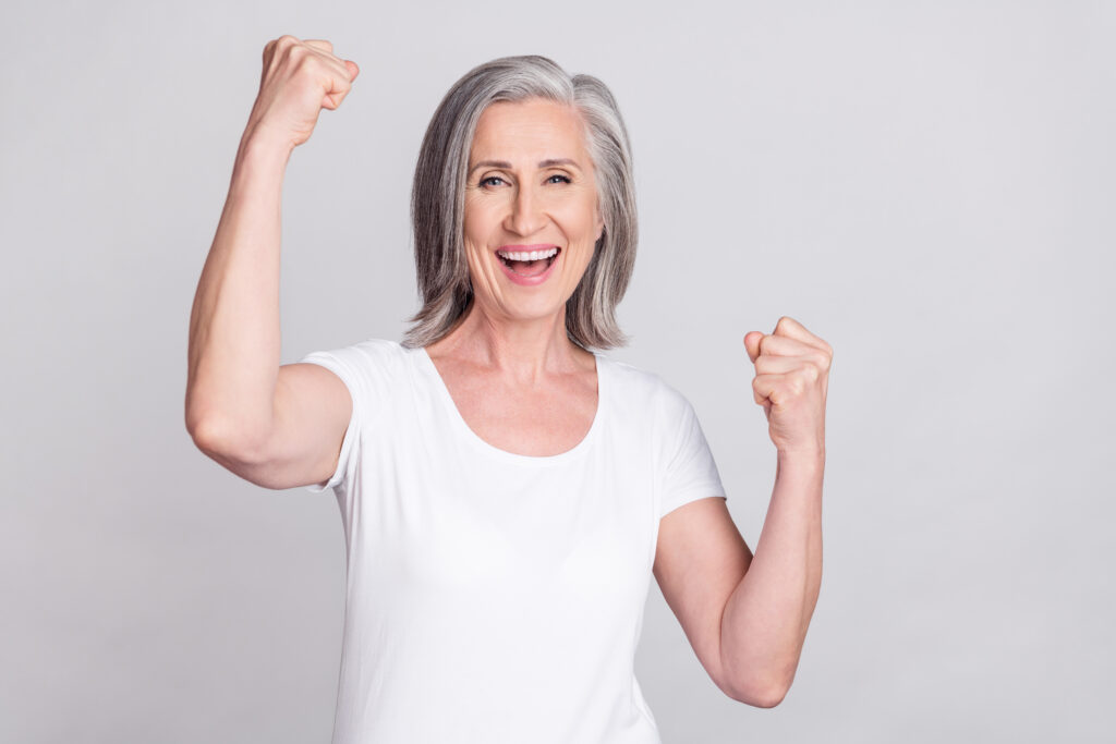 photo of aged woman happy positive smile rejoice victory fists hands isolated over grey color background